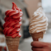 two ice cream cones, one is red and one is white